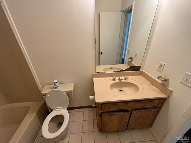 bathroom with tile patterned floors, vanity, toilet, and a tub to relax in