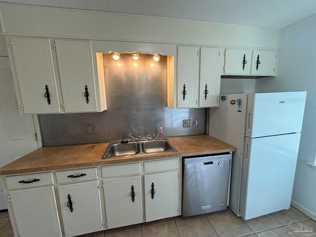 kitchen featuring sink, white cabinets, stainless steel dishwasher, white fridge, and light tile patterned flooring