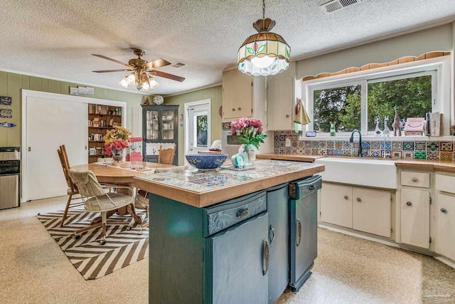 kitchen featuring sink, decorative light fixtures, a wealth of natural light, and black dishwasher