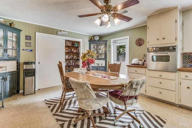 dining area with crown molding, ceiling fan, and a textured ceiling