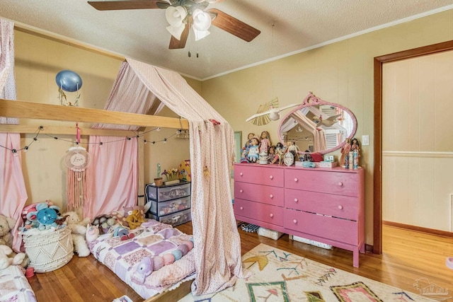 bedroom featuring crown molding, ceiling fan, hardwood / wood-style flooring, and a textured ceiling