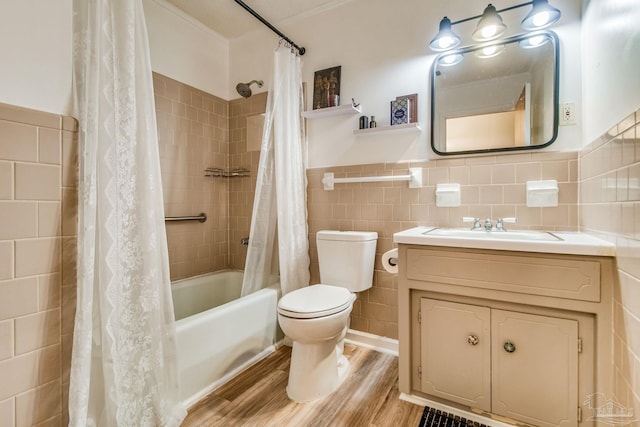 full bathroom featuring toilet, wood-type flooring, tile walls, vanity, and shower / bath combo