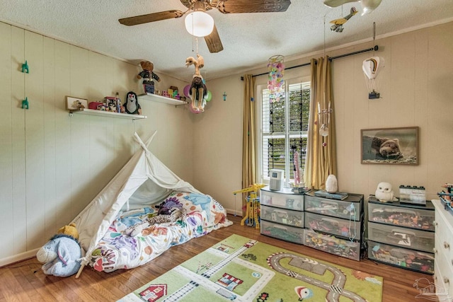 bedroom featuring hardwood / wood-style flooring, ceiling fan, and a textured ceiling