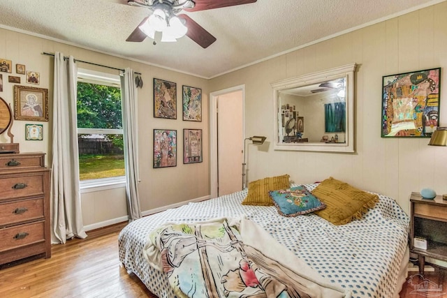 bedroom with ornamental molding, a textured ceiling, and light wood-type flooring