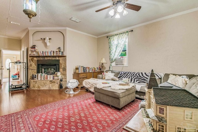 living room featuring hardwood / wood-style floors, crown molding, a fireplace, and a textured ceiling