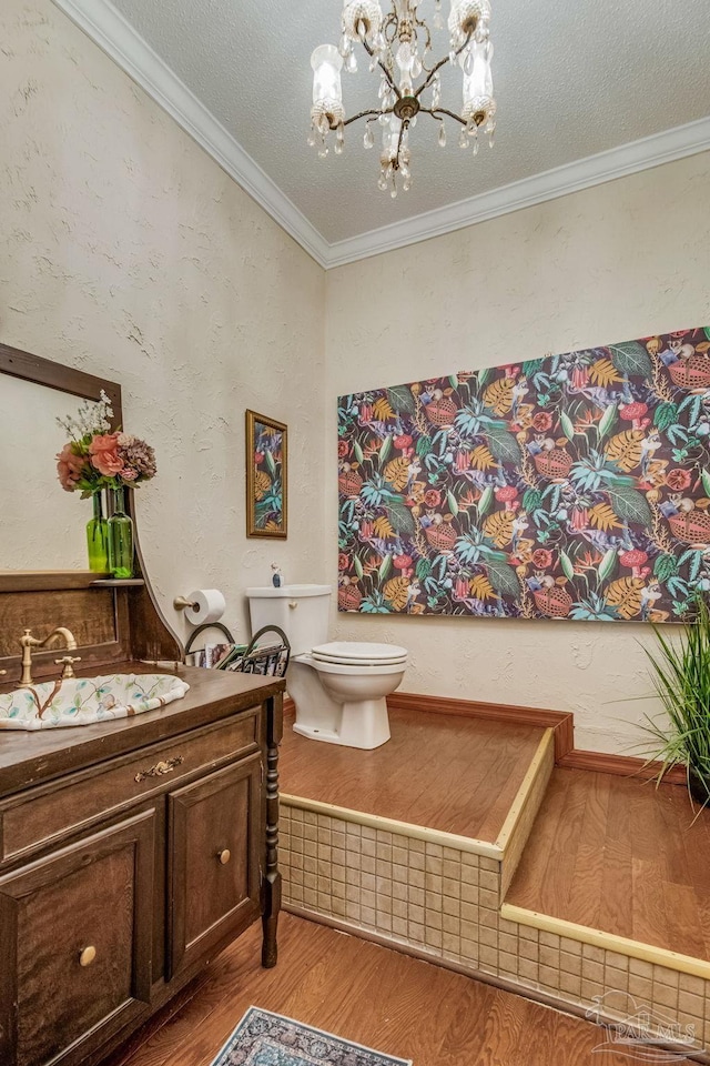 bathroom featuring wood-type flooring, a chandelier, crown molding, and toilet