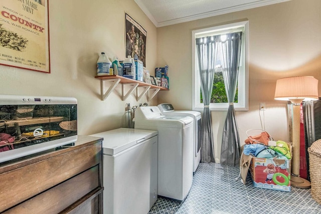 laundry room with ornamental molding and washing machine and clothes dryer