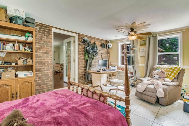 bedroom featuring light tile patterned floors, ceiling fan, and brick wall