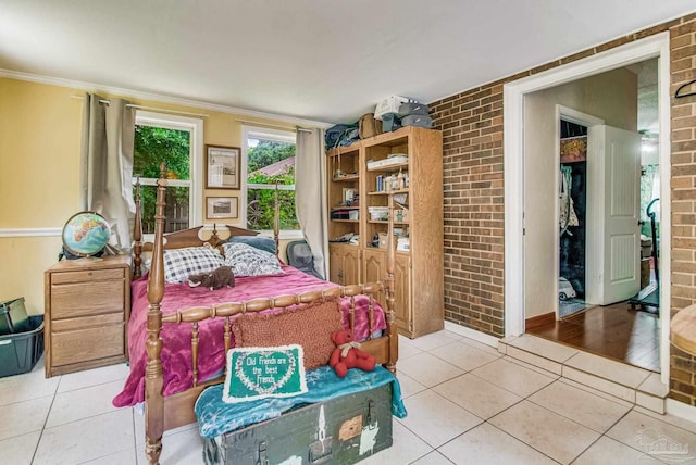 tiled bedroom with crown molding and brick wall