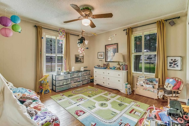 playroom with hardwood / wood-style flooring, a textured ceiling, and a wealth of natural light