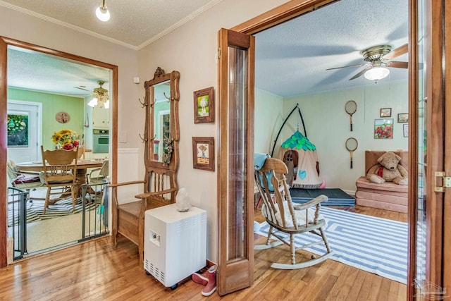 interior space with hardwood / wood-style flooring, crown molding, and a textured ceiling