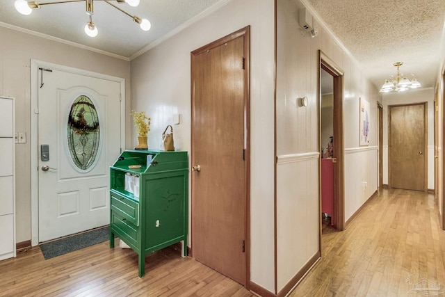 entrance foyer featuring a notable chandelier, a textured ceiling, and light hardwood / wood-style flooring