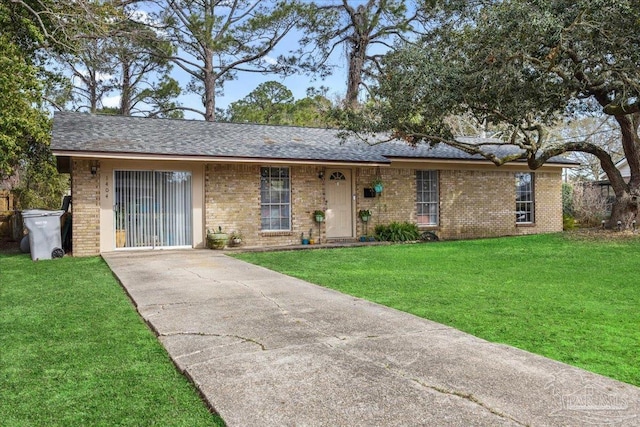 ranch-style home featuring a shingled roof, a front yard, and brick siding