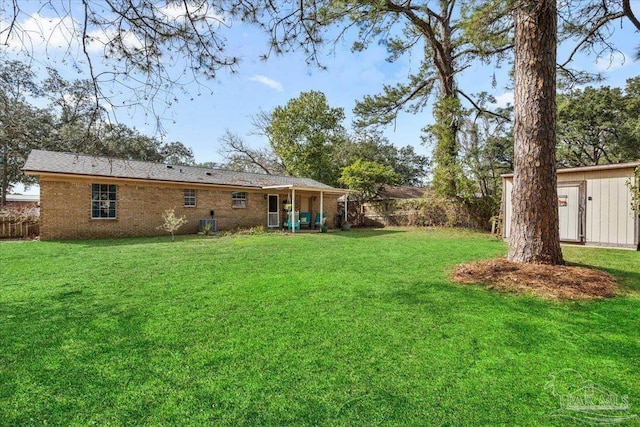 1404 Stanford Rd, Gulf Breeze, FL 32563 - view of yard with a storage unit, fence, and an outbuilding