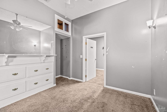 unfurnished bedroom featuring ceiling fan, light colored carpet, and a textured ceiling