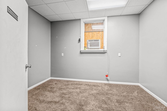 carpeted empty room featuring a drop ceiling and cooling unit