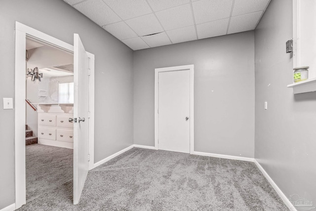 spare room with a paneled ceiling and carpet floors