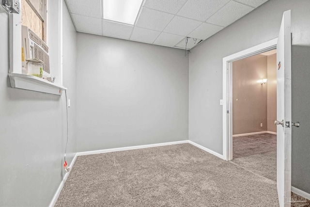 empty room with a drop ceiling and carpet floors