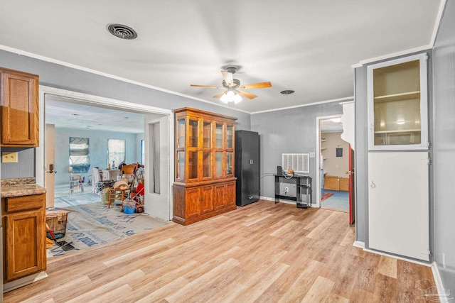 interior space with ceiling fan, light wood-type flooring, and crown molding