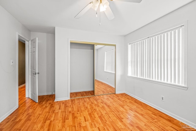 unfurnished bedroom featuring ceiling fan, a closet, and light wood-type flooring