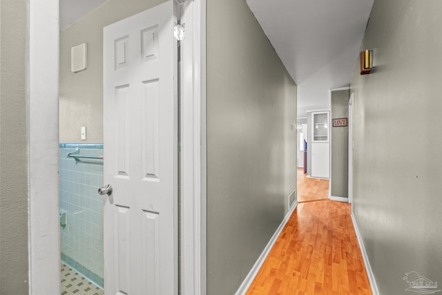 hall featuring tile walls and light wood-type flooring