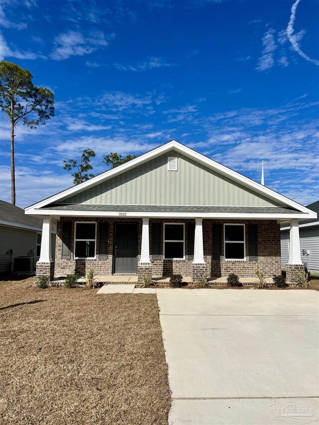 view of front of property with cooling unit, a porch, and a front yard