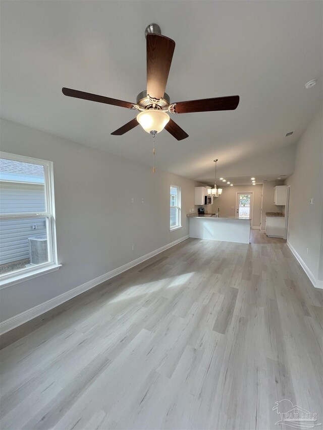 kitchen featuring kitchen peninsula, light stone countertops, gray cabinetry, stainless steel appliances, and sink