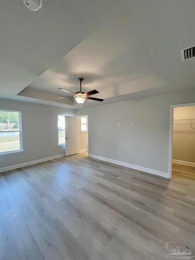 unfurnished living room featuring ceiling fan with notable chandelier, dark hardwood / wood-style floors, and vaulted ceiling