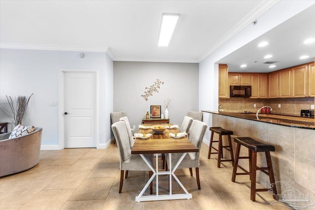 dining space featuring ornamental molding and light tile patterned flooring