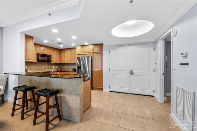 kitchen featuring stainless steel fridge with ice dispenser, kitchen peninsula, a breakfast bar, light tile patterned floors, and ornamental molding