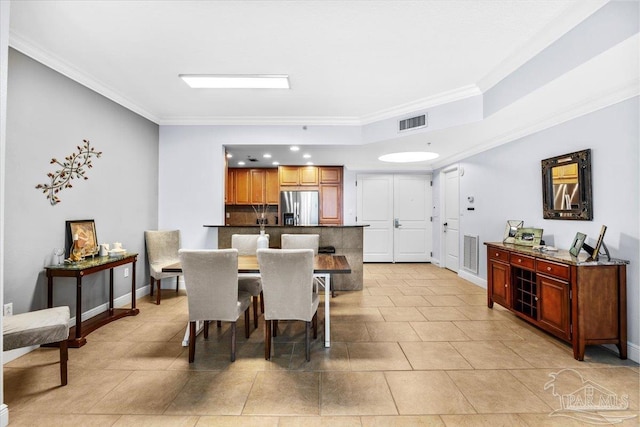 dining room featuring light tile patterned floors and crown molding