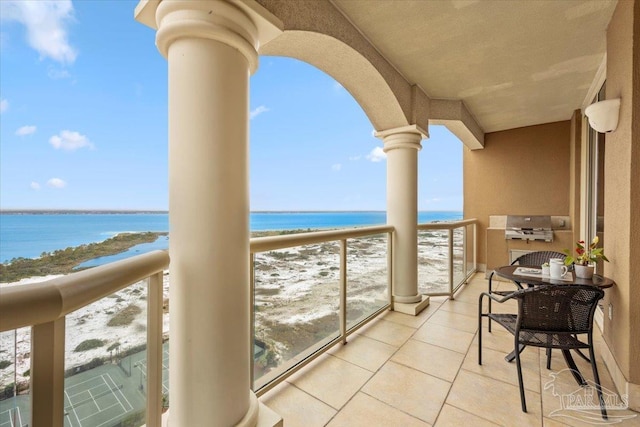 balcony featuring a grill, a water view, and a beach view