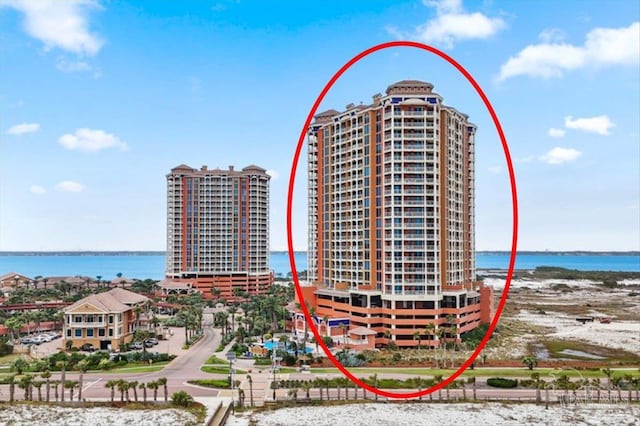 view of building exterior featuring a water view and a view of the beach