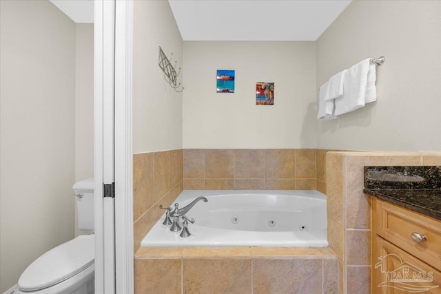 bathroom with tiled bath, vanity, and toilet