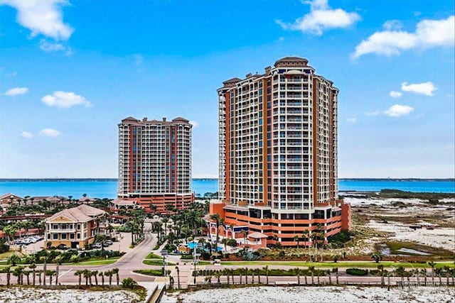 view of building exterior with a water view and a view of the beach