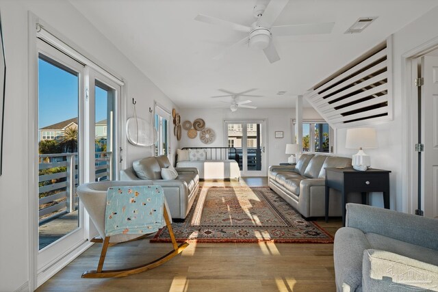 living area featuring ceiling fan, french doors, wood finished floors, and visible vents