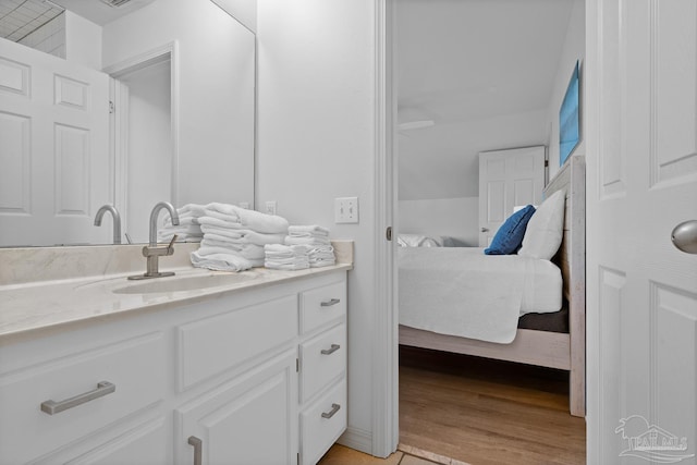 bathroom with visible vents, connected bathroom, vanity, and wood finished floors