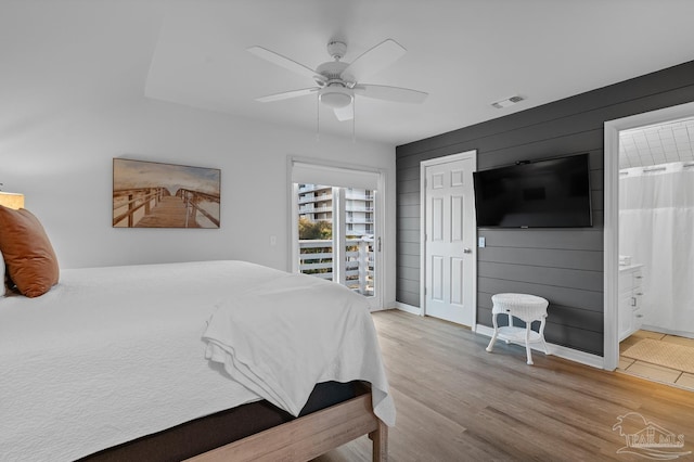 bedroom featuring connected bathroom, wood finished floors, a ceiling fan, visible vents, and access to exterior