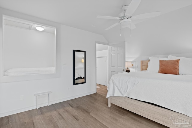 bedroom with lofted ceiling, ceiling fan, baseboards, and wood finished floors
