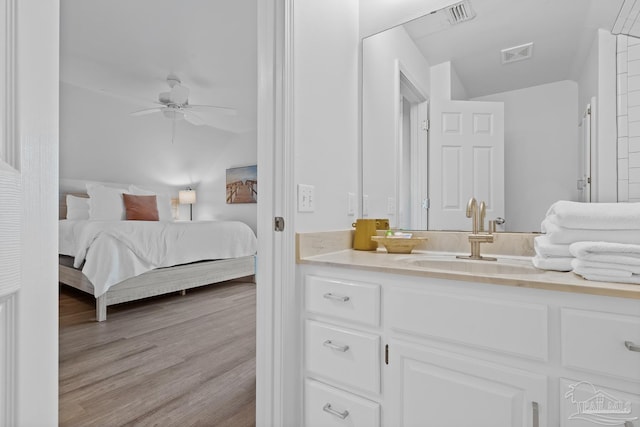 bedroom with wood finished floors, a sink, visible vents, and a ceiling fan