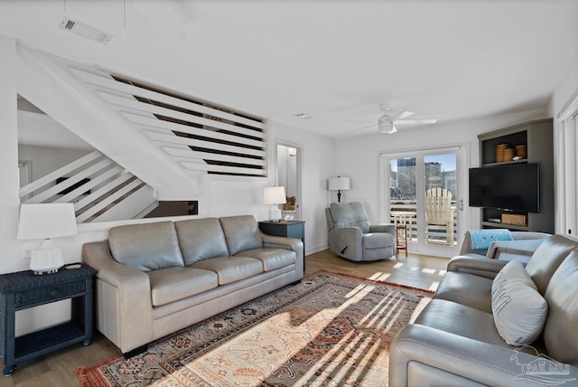 living room featuring visible vents, ceiling fan, and wood finished floors