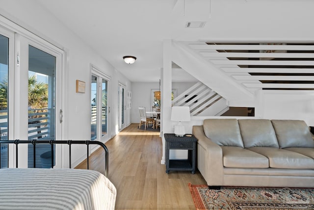 living area with light wood-style floors and visible vents