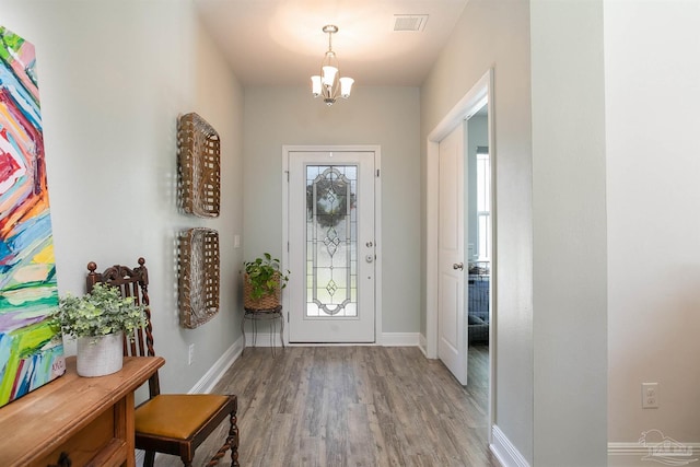 12806 Island Spirit Dr, Pensacola, FL 32506 - entrance foyer featuring a notable chandelier, baseboards, visible vents, and light wood-style floors
