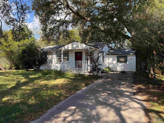 view of front facade with covered porch, driveway, and a front lawn