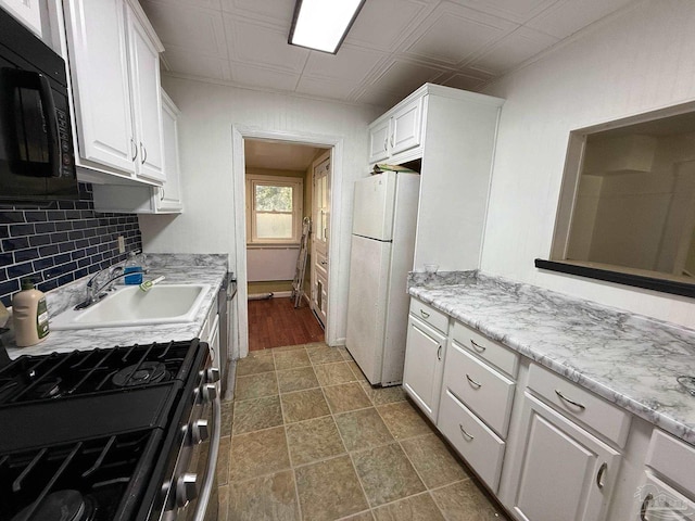 kitchen featuring stainless steel appliances, a sink, white cabinets, backsplash, and an ornate ceiling