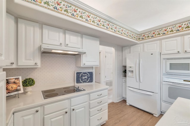 kitchen featuring light countertops, white cabinets, under cabinet range hood, and white appliances