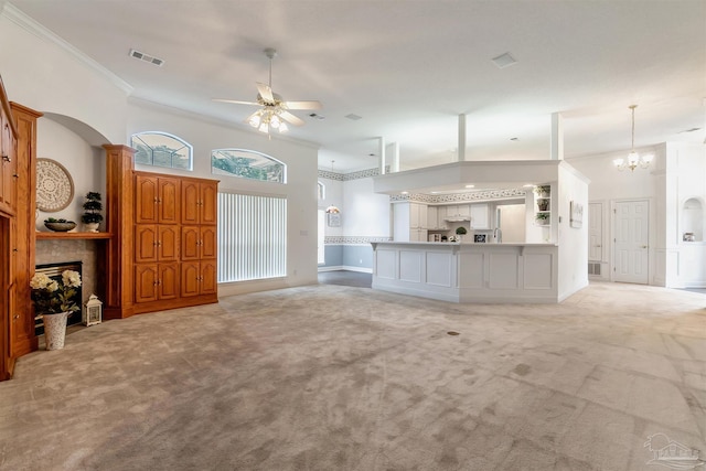 unfurnished living room featuring crown molding, ceiling fan with notable chandelier, light carpet, a tile fireplace, and visible vents