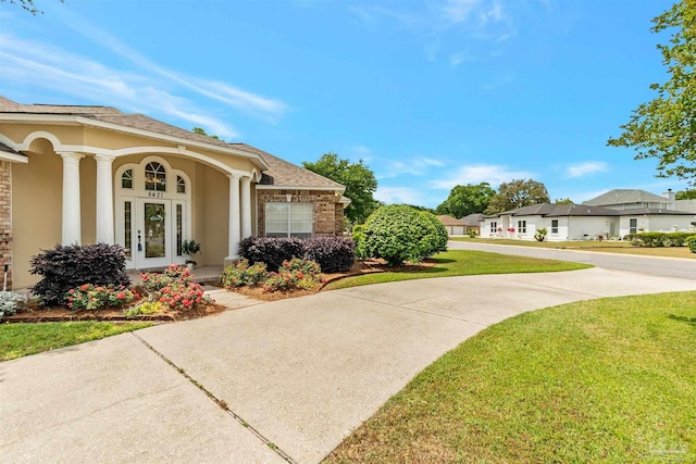view of property exterior with a lawn, brick siding, a residential view, and stucco siding