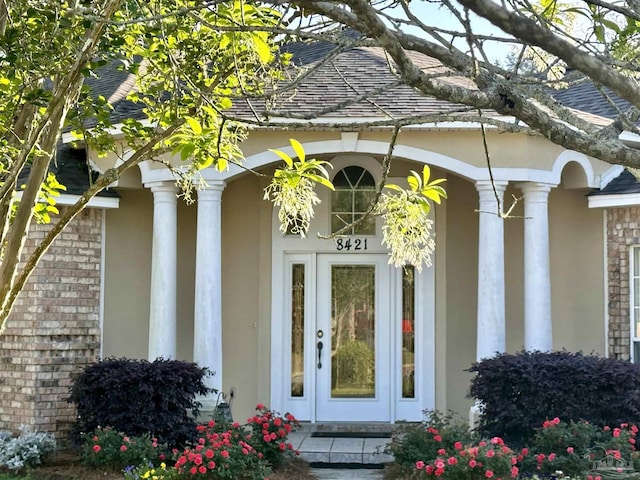 doorway to property with stucco siding and covered porch