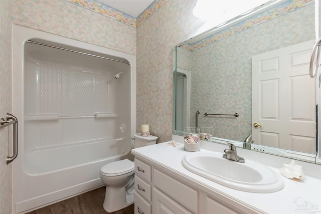bathroom featuring wallpapered walls, wood finished floors, vanity, and toilet